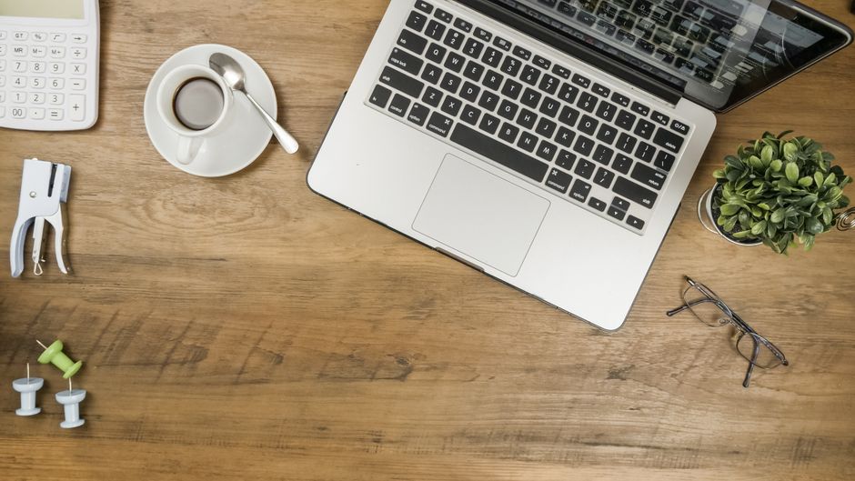 A keyboard and notebook on a desk